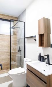 um banheiro com vaso sanitário e box de vidro em Fully Renovated Beachside with Oceanview 1 Bedroom Unit 5 em Dorado