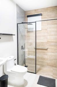 a bathroom with a toilet and a glass shower door at Fully Renovated ADA-Accessible Beachside with Oceanview 1 Bedroom Unit 6 in Dorado