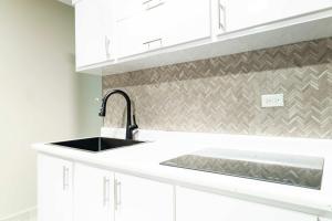 a kitchen with white cabinets and a sink at Fully Renovated Beachside with Oceanview 1 Bedroom Unit 7 in Dorado
