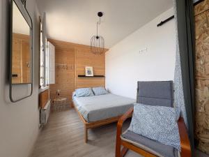 リバデオにあるApartamentos Ribadeoのベッドと椅子のある小さな寝室