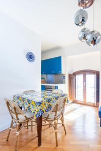 een keuken met een tafel met stoelen en blauwe kasten bij Elegante dimora - nel centro di Roma in Rome