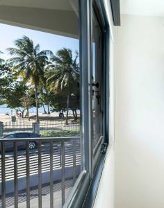 a window with a view of the beach at Fully Renovated Beachside with Oceanview 1 Bedroom Unit 8 in Dorado