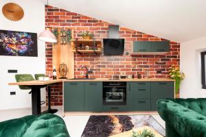 a kitchen with green cabinets and a brick wall at Apartman Rio in Rovinj
