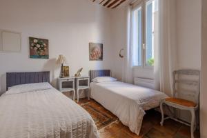 a bedroom with two beds and a window at Provence Village House 84 in Beaumes-de-Venise
