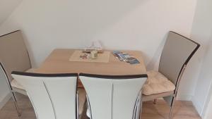 a dining room table with two chairs and a box of tissues at Kleine Möwe in Wilhelmshaven +1 photo