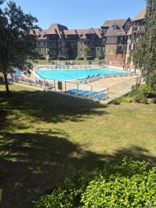 a large swimming pool in the middle of a park at L'instant Deauville - F2 avec Piscine - Résidence du Golf in Deauville