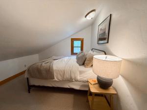 une chambre avec un lit et une table avec une lampe dans l'établissement Big Mountain Basecamp, à Whitefish