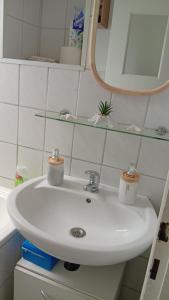 a white sink in a bathroom with a mirror at Kleine Möwe in Wilhelmshaven