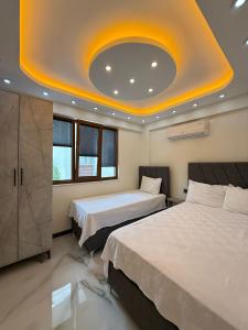a bedroom with two beds and a yellow ceiling at Çakır Residence in Trabzon