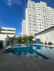 ein Schwimmbad vor einem großen Gebäude in der Unterkunft Castelão Apartment in Fortaleza