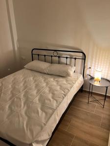 a bedroom with a bed and a table with a lamp at Nicks apartments in Ierissos