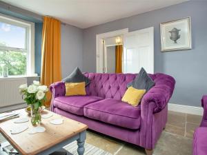 a purple couch in a living room with a table at Uk45542-The Farm House in Sticklepath
