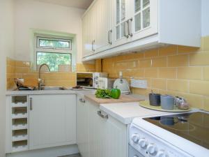 a kitchen with white appliances and yellow tiles at Uk45542-The Farm House in Sticklepath +32 photos