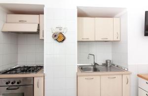 eine Küche mit weißen Schränken und einem Waschbecken in der Unterkunft Micca House in Ostuni