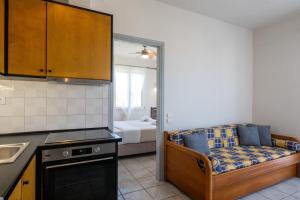 a kitchen with a couch and a bed in a room at Mythos Suites-Apollo apartment in Methoni
