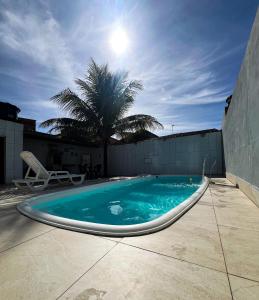 a swimming pool on top of a building with a palm tree at Casa Com Piscina - Mongaguá - Disponível Feriado Carnaval in Mongaguá