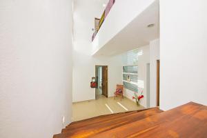 a hallway of a house with white walls and wooden floors at Casa CAMPANA, Privada, Piscina Privada, 3 Cuadras Malecón in Cozumel +15 photos