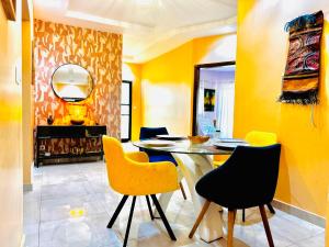 a dining room with yellow walls and a table and chairs at Teranga sn in Dakar