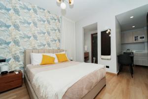 a bedroom with a bed with yellow pillows and a desk at Downtown Punta Cana Central Park 1 Bedroom B-300 in Punta Cana +27 photos