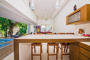 a kitchen with a large white table and chairs at Casa CAMPANA, Privada, Piscina Privada, 3 Cuadras Malecón in Cozumel