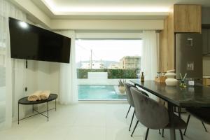 コリントスにあるBEQUEST Gold Luxury suitesのダイニングルーム(テーブル付)が備わり、プールの景色を望めます。