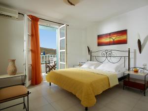 ein Schlafzimmer mit einem gelben Bett und einem Balkon in der Unterkunft Asterias Boutique Hotel in Pachaina