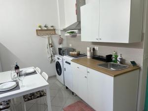 a white kitchen with a sink and a washing machine at Casa Ariel in Avola +9 photos