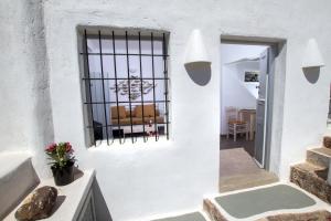 ピルゴスにあるSkyline Villaの白い壁の窓付きの客室です。