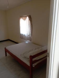 a bed in a room with a window at Shalom appartement in Paramaribo