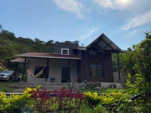 a small house with flowers in front of it at Quinta Vacacional Yunguilla, Santa Isabel, Azuay in Santa Isabel