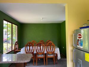 a dining room with a table with chairs and a refrigerator at Quinta Vacacional Yunguilla, Santa Isabel, Azuay in Santa Isabel