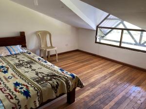 a bedroom with a bed and a window at Quinta Vacacional Yunguilla, Santa Isabel, Azuay in Santa Isabel