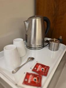 a tea kettle and cups on a white tray at Aura Garden City Hotel in Cairo +30 photos