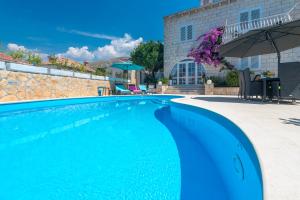 a swimming pool with blue water in front of a building at Villa Ida in Dubrovnik