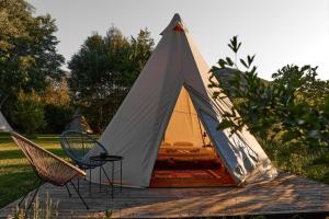 a tent with a bed in it on a deck at Gipsy Village Park Hotel in Asuretʼi