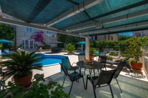 a patio with a table and chairs and a pool at Villa Ida in Dubrovnik