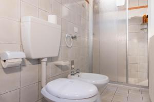 a white bathroom with a toilet and a sink at Villa Sanziana in Menaggio