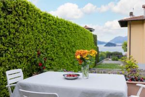 a white table with a vase of flowers on it at Villa Sanziana in Menaggio