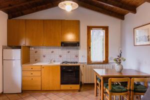 a kitchen with wooden cabinets and a table and a refrigerator at Villa Sanziana in Menaggio