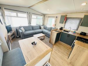 a living room with a couch and a table at 2 Bedroom Caravan FF17, Fairway, Sandown, Isle of Wight in Isle of Wight