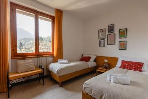 a bedroom with two beds and a large window at Villa Sanziana in Menaggio