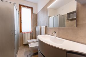 a bathroom with a sink and a toilet and a mirror at Villa Sanziana in Menaggio