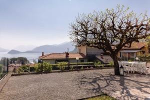 a house with a tree and a table and chairs at Villa Sanziana in Menaggio
