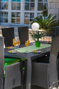 a table with chairs and wine glasses on it at Villa Ida in Dubrovnik +51 photos