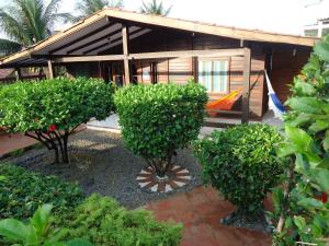 a house with trees in front of it at Pousada Raio de Sol in Fernando de Noronha
