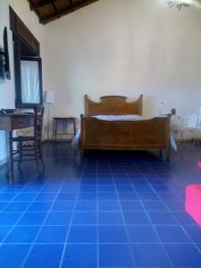 a bedroom with a bed and a desk and a blue tile floor at La Casa Dell'antiquario in Graniti