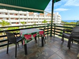 un tavolo e sedie su un balcone con vista sull'oceano di Cristimar Roja Beach a Los Cristianos