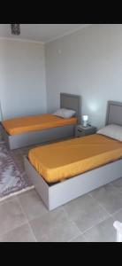 two twin beds in a room with at Joli Loft F5 location Bousmail in Bou Ismaïl