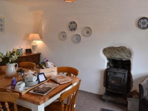 a dining room with a table and a wood stove at Ty Hen in Llangwnadl