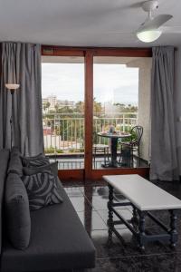 a living room with a couch and a table and a balcony at Juanvi's Corner in Costa de Adeje